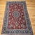 This vintage Persian Yazd rug from the mid-20th century features a refined floral design highlighted by a rare pomegranate...