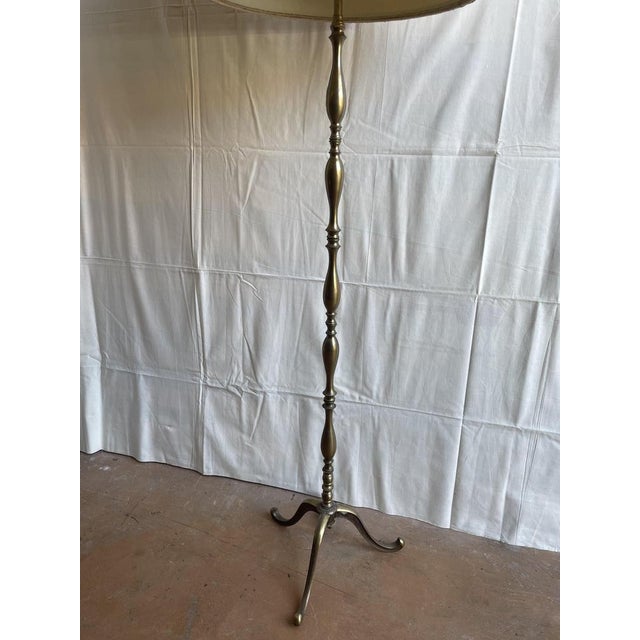 Vintage Maison Jansen-style floor lamp in wrought brass from the 1930s. Tripod base, three light sources, one of which is...