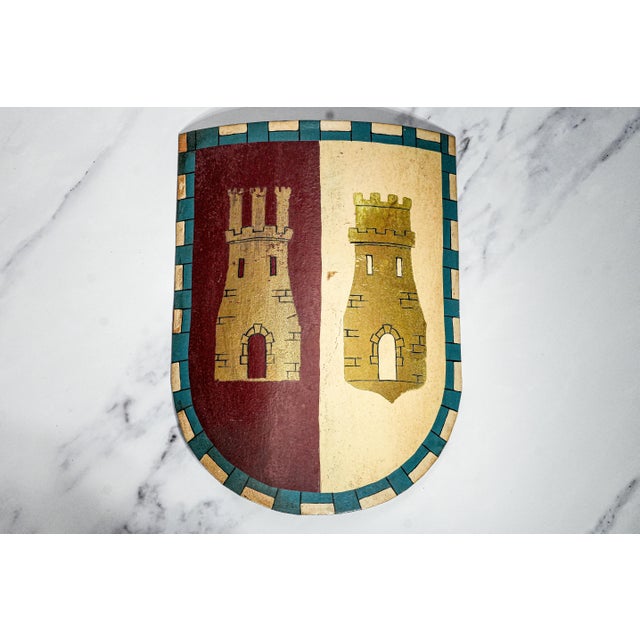 A captivating trio of antique metal shields, each meticulously hand-painted in the English medieval style, circa 1900....