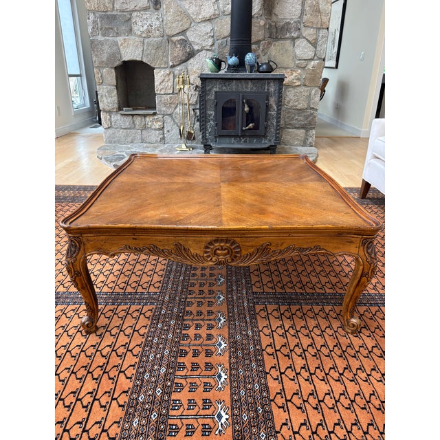 Walnut coffee table with fleur-de-lis patterns along the edges, beautiful wood and graceful design. Excellent condition,...