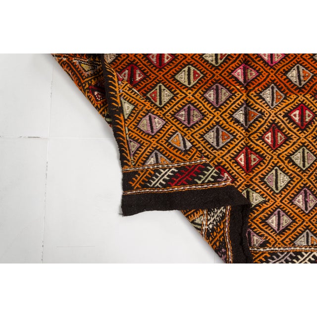 This is a vintage Turkish Oushak rug from the Mid 20th Century. The piece was hand-knotted.