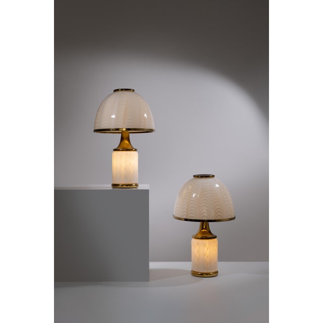 F. Fabbian table lamps, made in italy in 1970s. Rare pair of table lamps with cream colored murano glass decorated with...