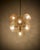 A classic mid-century design, this Sputnik-style chandelier features hand-blown bubble glass in a warm amber tone,...
