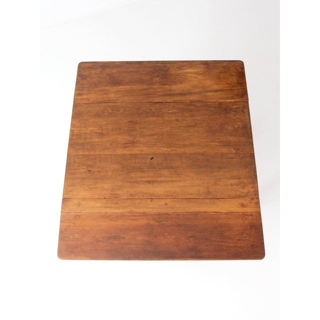 A beautifully patinated antique American country drop-leaf table with a graceful, understated silhouette. The richly aged...