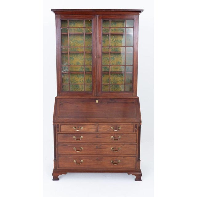 This quality Georgian mahogany bureau bookcase stands upon '' o gee'' feet. The bureau section featuring an arrangement of...