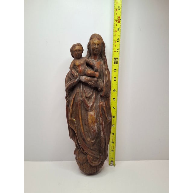 This is an antique wooden relief sculpture depicting the Virgin Mary (Madonna) holding the infant Jesus (Child). Carved...