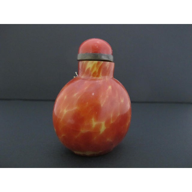 Vintage Chinese simulated realgar glass snuff bottle, featuring vibrant swirling red and yellow glass patterns meant to...