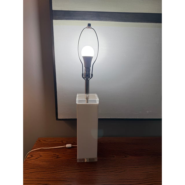 Vintage 1970s white lucite column lamp with 1” clear platform and top. The lamp was designed by George Bullio (see maker’s...