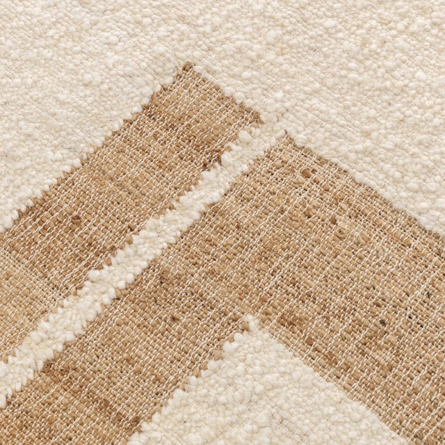 Natural jute and ivory wool rug. Features a bold symmetrical geometric design mixed with soothing airy neutral tones which...