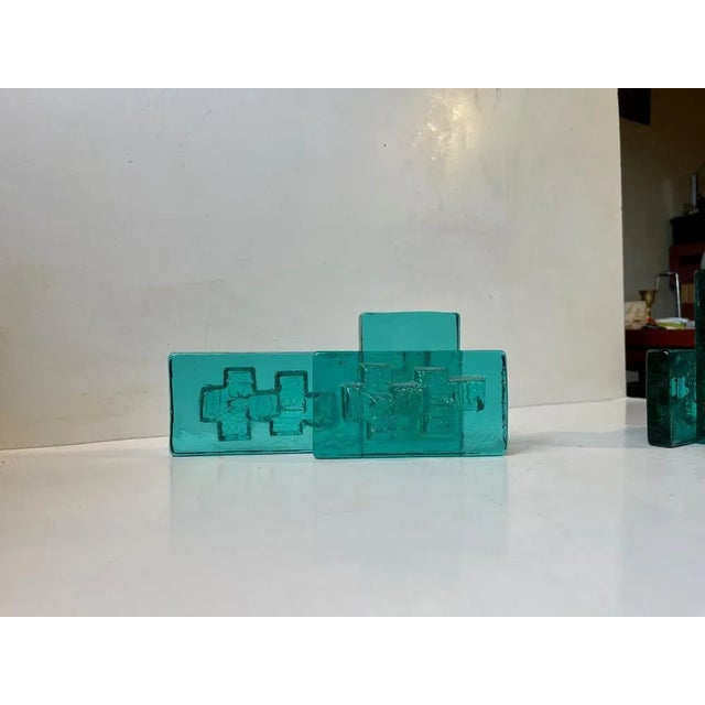 A set of sculptural candleholders in pressed blue relief glass. Suitable for your inside window sills or shelf. Made in...