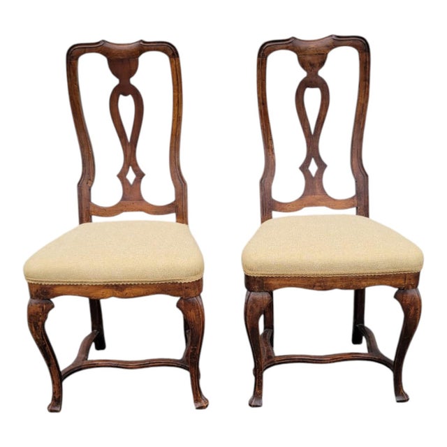 Pair of authentic 18th century Italian walnut chairs with their original finish and hand-carved details. Each chair...