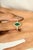 Radiating timeless elegance, this exquisite ring features a vivid 1.05 carat marquise-cut emerald, framed by a halo of...