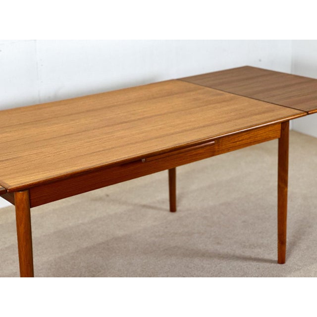 This stunning Danish teakwood extending table from the 1960s showcases the timeless elegance and craftsmanship of mid-...