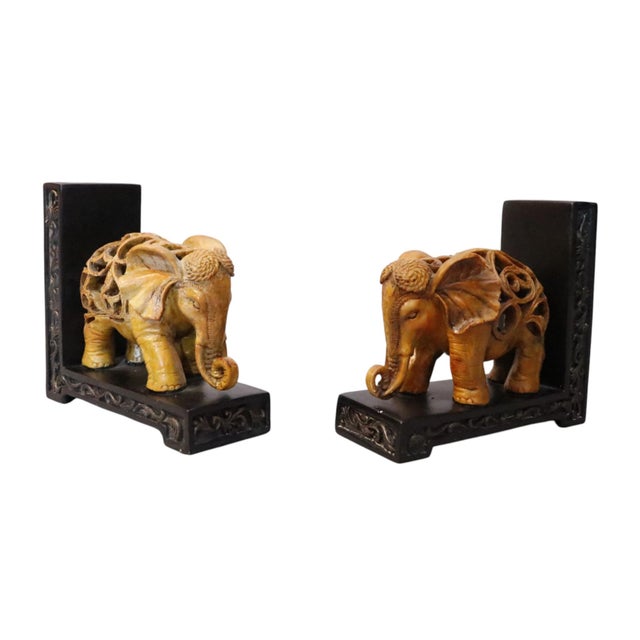 A pair of hand carved resin elephant bookends. Intricate pierced carving decorates the back of each elephant, with fine...