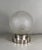 SABINO A French art deco table lamp, circa 1930. In nickel plated solid brass or bronze holding a small sphere in frosted...
