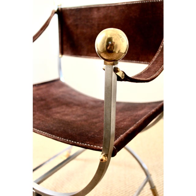 A striking mid-century Savonarola or curule chair in the style of Maison Jansen, circa 1960s–1970s. The chair features a...