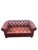 A luxurious tufted leather chesterfield sofa in a burgundy / brick red. The sofa has nicely rolled arms, boasts brass...