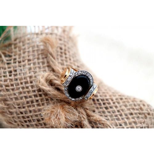 Gold ring with diamond flakes (30) and a brilliant cut one in the center, set on oval onyx. Metal: Gold. Origin:...