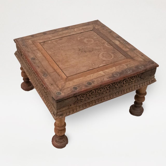 Rectangular top with sunflower head to center and red-edge metal fleurette studs, resting on shaped legs. Frieze inset...