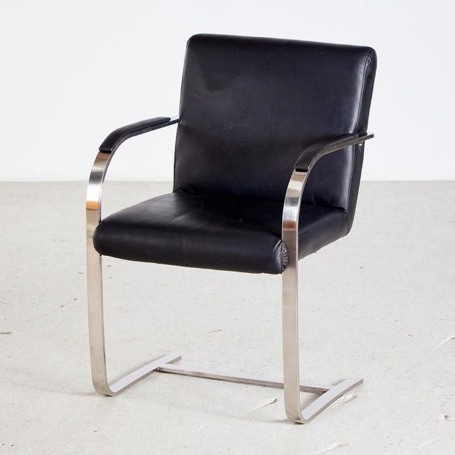 Bauhaus style armchair from the 1980s. The chair has a cantilevered steel base, leather covered armrests and upholstery....