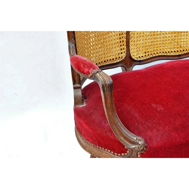 Louis XV style bench in mahogany and cane backrest. The armrests, legs and backrest are carved. Caning and seat in good...