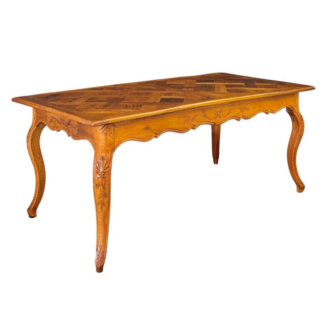 A late 18th/early 19th century Louis XV provincial dining table in oak comfortably seating 6-8; having a parquetry top of...