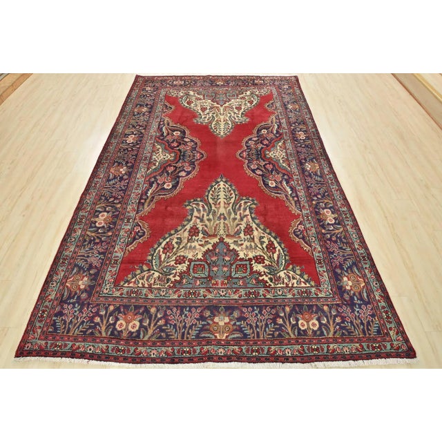 An authentic semi-antique traditional Tabriz rug, hand-knotted with an all-wool pile on a cotton foundation. This oriental...