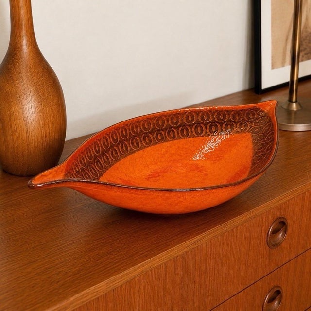 This large glazed ceramic centerpiece bowl is straight from Italy in the 1960s/70s. Its long, shuttle-shaped silhouette,...
