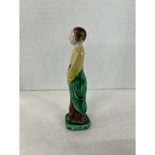 Small single Chinese export pottery figurine with green and yellow glaze decoration.