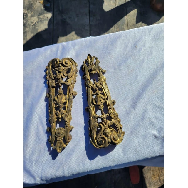 This pair of 19th Century French ormolu bronze mounts features finely detailed floral and scroll designs with remnants of...