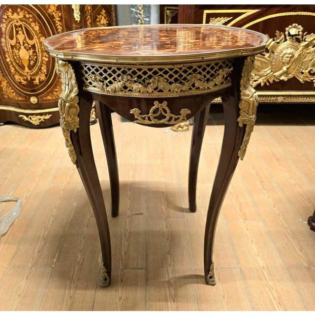 An exquisite French Louis XV style accent table showcasing a beautifully crafted marquetry top, elegant cabriole legs, and...