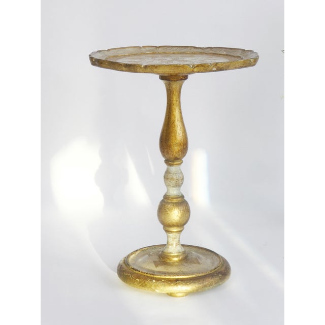 Vintage Florentine style wooden table with gold and white details made in Italy. The plant stand has a round top and...