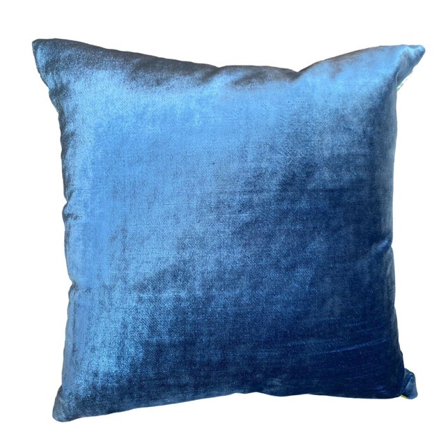 This pillow features a dual-sided design with a lush, blue velvet on one side, exuding elegance and softness, while the...