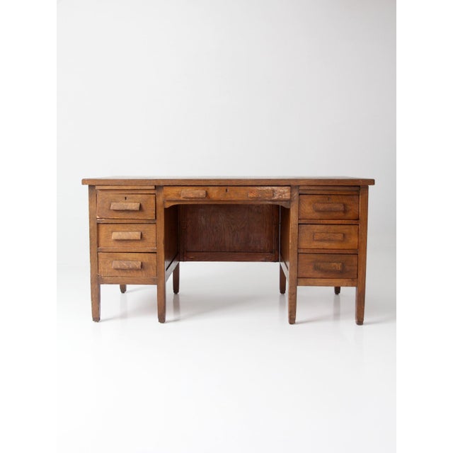 An early 20th century oak double pedestal desk with a grounded presence and clean Arts and Crafts movement lines. the form...