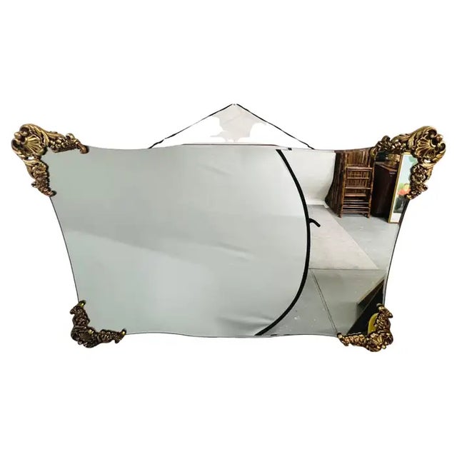 A striking and sculptural Mid-Century Baroque Revival wall mirror, distinguished by its gently undulating silhouette and...