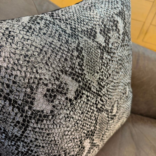 The cover carries a large-scale python snakeskin pattern across its full face, the oversized diamond-shaped scale motif...