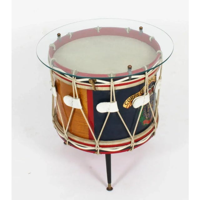 This is an elegant vintage brass and leather military drum converted into a side table, dating from the early 20th...