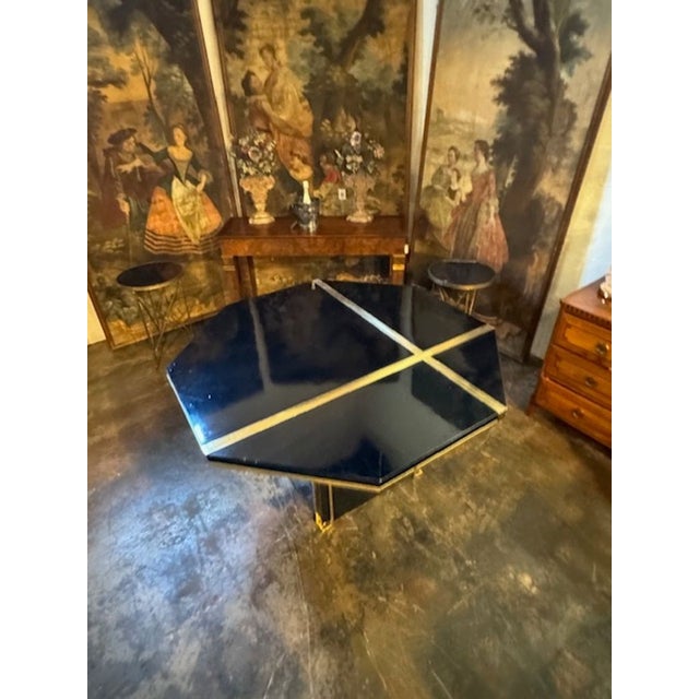 The Modern Italian Black Lacquer and Brass Center Table after Jean Claude Mahey is a stylish and elegant piece of...