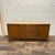 Drexel heritage credenza featuring leather pulls, woven drawer fronts, and a travertine top. There are 3 pull-out drawers...