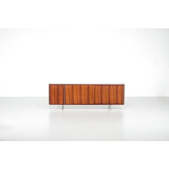Wooden sideboard with aluminum elements, two sliding doors, and adjustable interior shelves. Designed by Alberto Rosselli...
