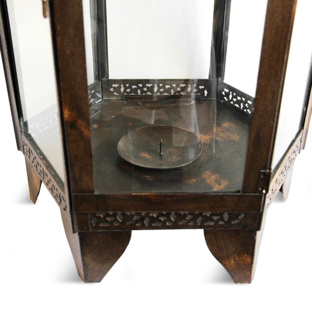 Handcrafted in iron and fitted with clear glass panels, this lantern brings an old-world architectural presence to any...