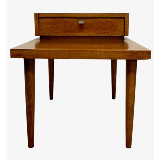 This vintage mid century modern nightstand by American of Martinsville features a clean, functional design with a raised...