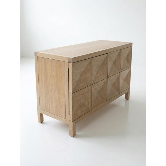Sculptural walnut two-door sideboard in a washed walnut finish featuring a geometric façade with diamond-shaped pyramid...