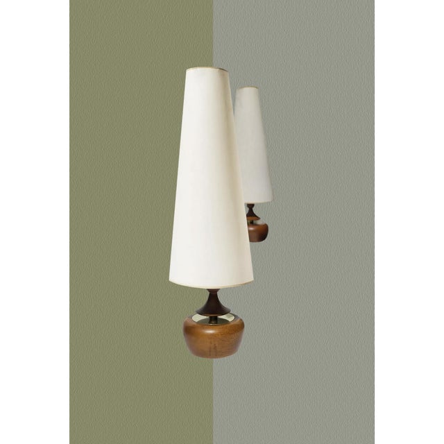 These gorgeous walnut and brass Modeline lamps have a unique low-rounded shape that is juxtaposed with a tall conical...