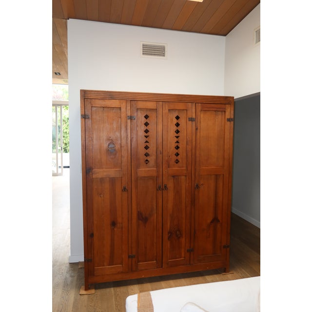 A handsome early 20th century four-door pine wardrobe with the unmistakable character of a European vestiaire — the...