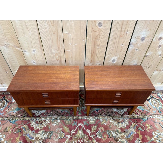 Pair of Scandinavian-style bedside tables, mid-20th century, crafted from solid teak. Each piece consists of a two-drawer...
