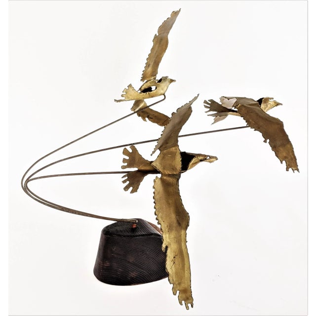 Dynamic brass sculpture of flying seagulls. Mounted on a wooden base. Brass tag reads "Ratafia"