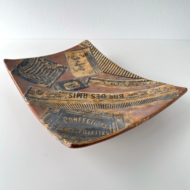 Vintage circa 1980s french ceramic decoupaged trompe l'œil tray. Striped pattern and authentic french labels are set in a...