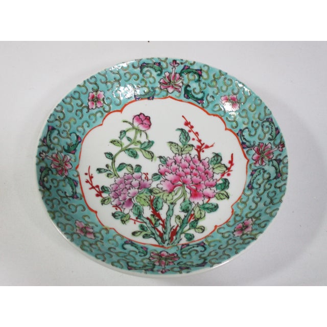 A Japanese bowl hand painted in Hong Kong. It is decorated with a floral center and a floral and scroll boarder, painted...
