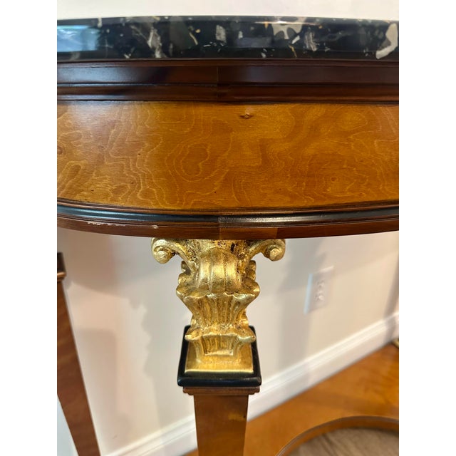 Elevate your entryway with this stunning Neoclassical-style demilune console. This elegant piece features a rich burlwood...